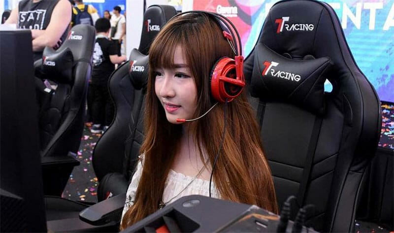 Cute Asian girl sitting in TT Racing Royale gaming chair