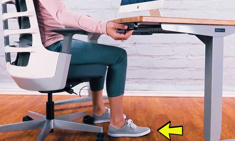 Woman sititng with planted feet while using a sit-to-stand desk