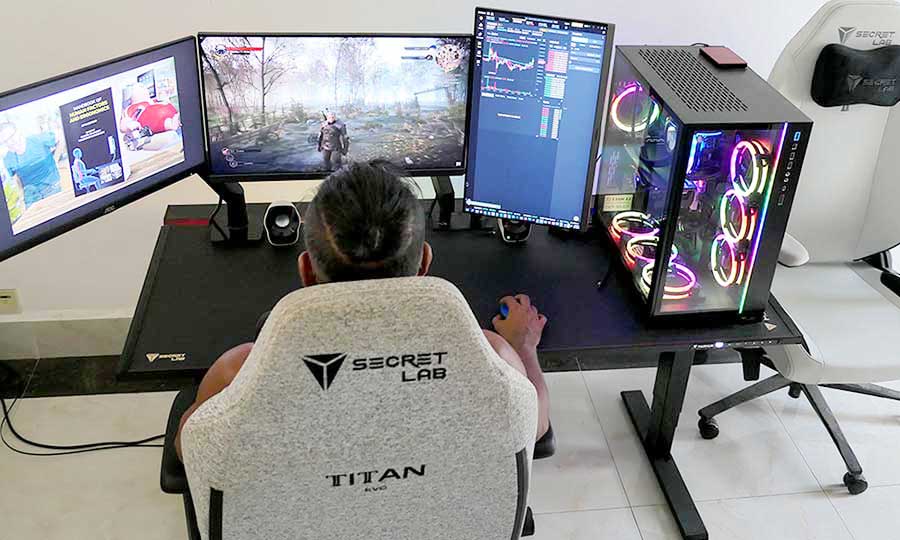 Rear overhead view of a man playing video games using a Secretlab Magnus Pro desk