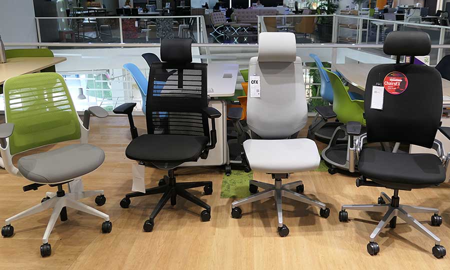 Four Steelcase office chairs posed together in a showroom
