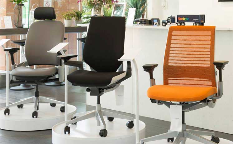 Three Steelcase ergonomic chairs posed in a showroom