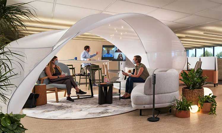 Happy office workers collaborating under a Steelcase work tent