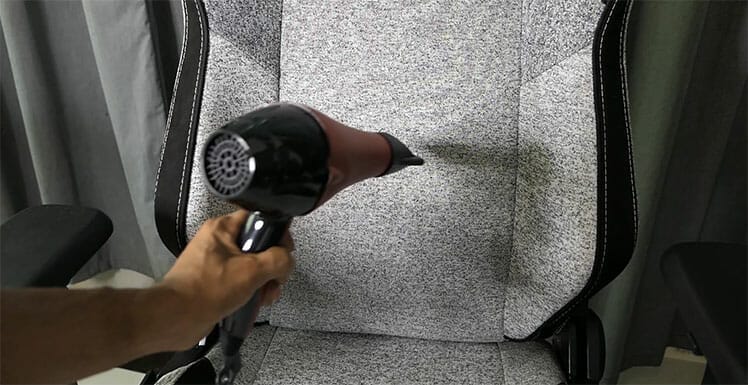 Using a blow dryer to clean fabric gaming chair