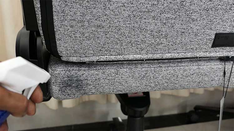 Testing a fabric cleaning solution on the back side of a gaming chair